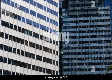 Abstract modern architecture background of two contrasting corporate office skyscraper buildings with reflection in windows in the financial district. Stock Photo