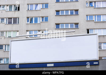 Wide blank billboard against block of flats condominium in the city. Stock Photo