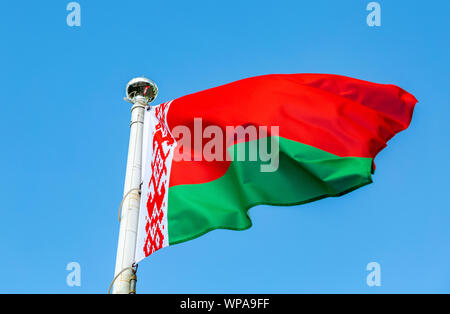 National flag of Belarus waving in the wind against the blue sky Stock Photo