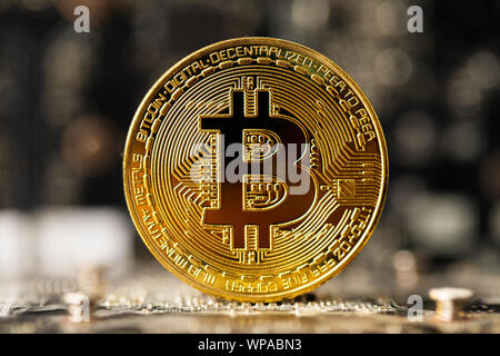 Dark gold bitcoin on crypto mining GPU circuit board computer hardware Stock Photo