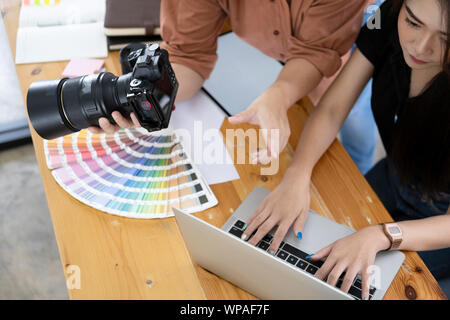 Photo artist and graphic desginer selecting pictures from camera. Stock Photo