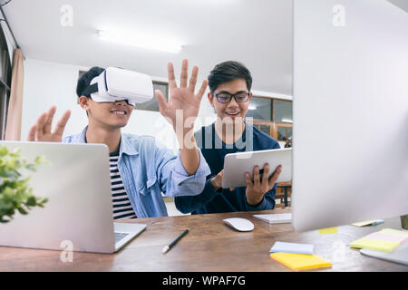 Young IT engineer and programmer testing software and working with Virtual Reality headset on. Programming, Software development, Education, VR, Tutor Stock Photo