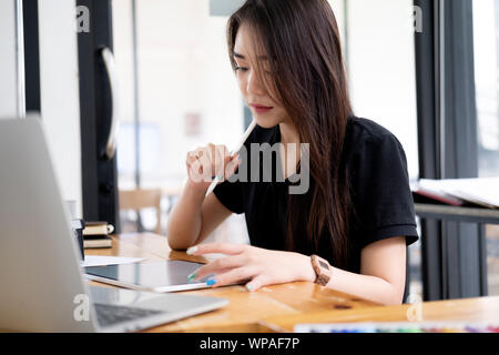 Graphic designer working at her desk in creative studio office. Stock Photo