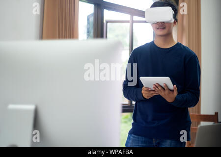 Young IT engineer and programmer testing software and working with Virtual Reality headset on. Programming, Software development, Education, VR, Tutor Stock Photo