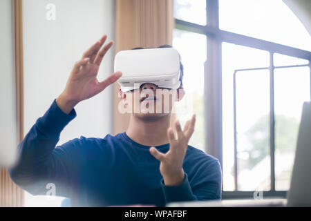 Young IT engineer and programmer testing software and working with Virtual Reality headset on. Programming, Software development, Education, VR, Tutor Stock Photo