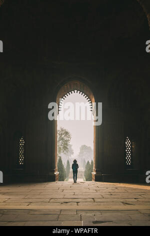 Woman during a foggy sunrise at Qutb complex, New Delhi, India Stock Photo