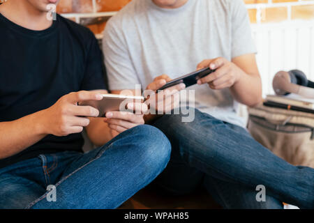 Young teenage men playing mobile game together. Stock Photo