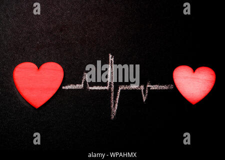 Hearts are connected by a single rhythm. Two hearts on a blackboard with a chalk heart-drawn rhythm Stock Photo