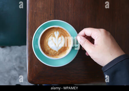 holding hot cofffee or latte coffee ,cappuccino Stock Photo