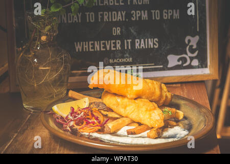 Atlantic Cod Fish And Chips Atlantic Cod is lean and white with a sweet, delicate taste which flakes tenderly.  Served with handcut chips, fresh slaw Stock Photo