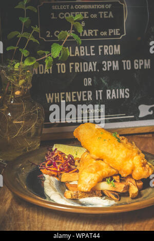 Atlantic Cod Fish And Chips Atlantic Cod is lean and white with a sweet, delicate taste which flakes tenderly.  Served with handcut chips, fresh slaw Stock Photo