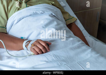 Patient in hospital in bed with emergency button Stock Photo