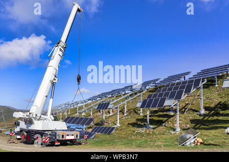 Professional worker installing solar panels on the green metal construction. Innovative solution for energy solving. Use renewable resources. Green en Stock Photo