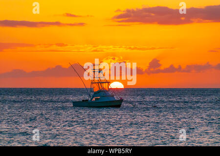 Beautiful sunset behind sport fishing boat with a flying bridge on Maui, Hawaii, USA Stock Photo