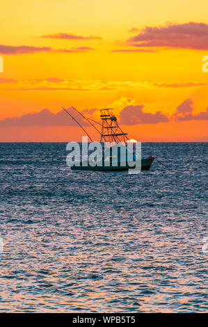 Beautiful sunset behind sport fishing boat with a flying bridge on Maui, Hawaii, USA Stock Photo