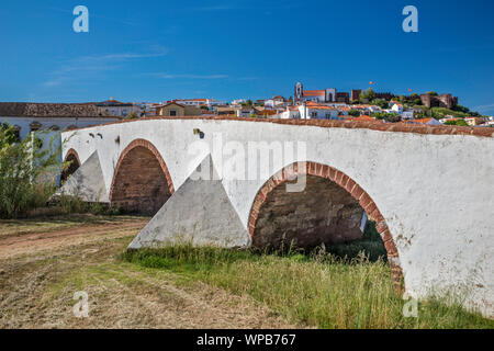 Roman bridge over Rio Arade, in distance Moorish castle and cathedral in town of Silves, Faro district, Algarve, Portugal Stock Photo