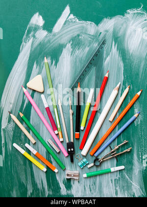 School supplies on green chalkboard  background - top view Stock Photo