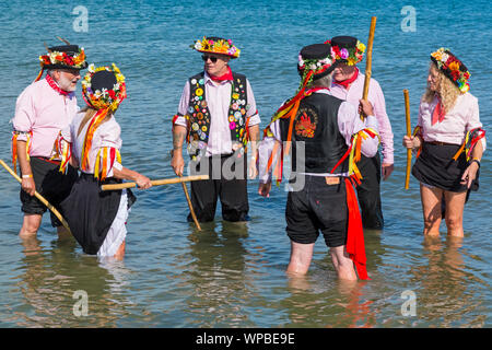 Swanage, Dorset UK. 8th September 2019. Crowds flock to the seaside town of Swanage to enjoy the dancing, with over 50 dance teams including morris dancing at Swanage Folk Festival. Morris dancers dance in the sea at the end of the two day festival on a warm sunny day. Morris dancers, members of Phoenix Morris dancing in the sea. Credit: Carolyn Jenkins/17�Թ����� Live News Stock Photo