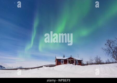 Northern Lights (Aurora borealis) above a Swedish red house in winter, Kungsleden, Province of Lapland, Sweden Stock Photo