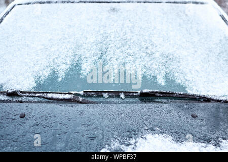 Close up of car windshield and wipers covered with ice and snow on a winter day Stock Photo