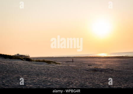 A beautiful sunset at the beach of Ameland, Friesland, North Sea white white sand and tidal waves Stock Photo