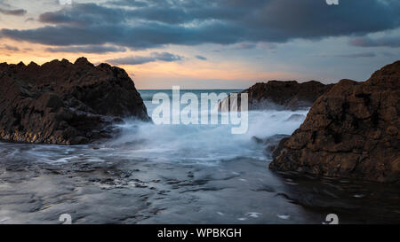 Waves crash over rocks at Westward Ho! beach in North Devon, UK Stock Photo