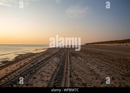 A beautiful sunset at the beach of Ameland, Friesland, North Sea white white sand and tidal waves Stock Photo