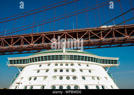 Lisbon, Portugal - September 2011: The cruise liner Independence of the Seas passing under the 25 De Abril suspension bridge in Lisbon Stock Photo