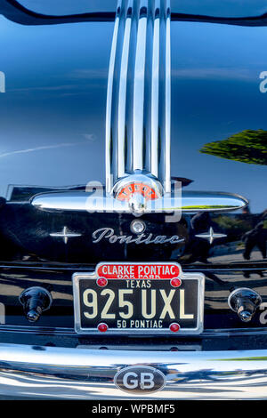 Pontiac badge on the trunk of a vintage car with a Texas USA registration plate and a GB sticker on the bumper Stock Photo