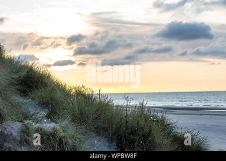 A beautiful sunset at the beach of Ameland, Friesland, North Sea white white sand and tidal waves Stock Photo