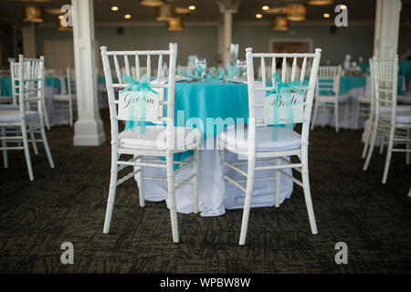 Table set up for wedding reception with chairs and signs saying Bride and Groom. Stock Photo