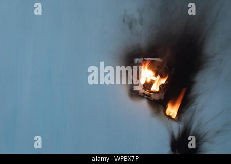 Apartment fire is caused by electrical outlet faults. Burnt and damaged electric plug socket from overload short circuit. Stock Photo