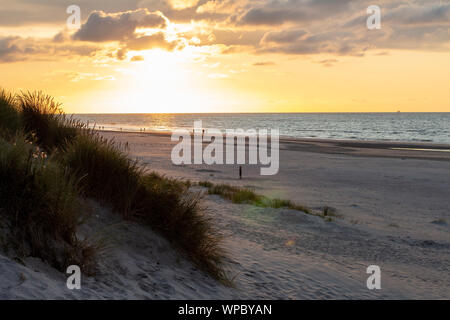 A beautiful sunset at the beach of Ameland, Friesland, North Sea white white sand and tidal waves Stock Photo