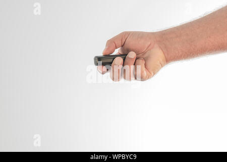 A hand pressing one of the buttons of a car wireless control on a white background. Space to write. Stock Photo