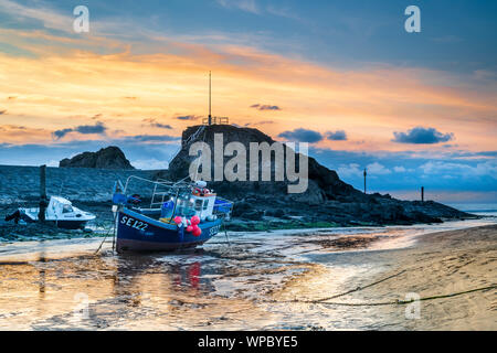 Bude, North Cornwall, England. Sunday 8th September 2019. UK Weather. After a warm and sunny day in the West of England, the breeze drops and the clouds gather as the sun sets over the breakwater and little harbour at Bude in North Cornwall. Terry Mathews/Alamy Live News. Stock Photo