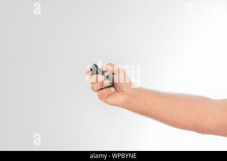 One hand holds a car wireless control on a white background. Space to write. Stock Photo