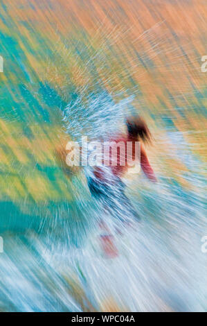 Teenage boy skimboarding on the tropical island of Kauai, Hawaii, USA Stock Photo