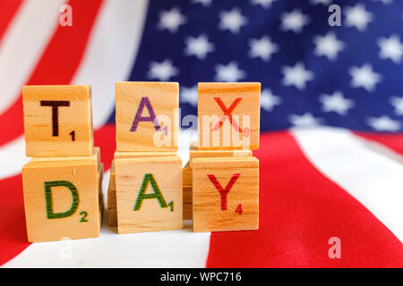 Tax day written with wooden letters to indicate the day of payment of taxes in america.