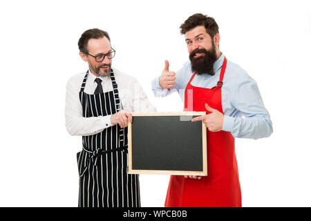 Men bearded bartender or cook in apron hold blank chalkboard. Workers wanted. Bartender with blackboard. Hipster bartender show blackboard copy space. Men bearded hipster informing you. Opening soon. Stock Photo