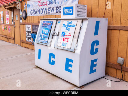 A two door ice container that holds bags of ice for sale outside of a beer distributor in summer time, Pittsburgh, Pennsylvania, USA Stock Photo