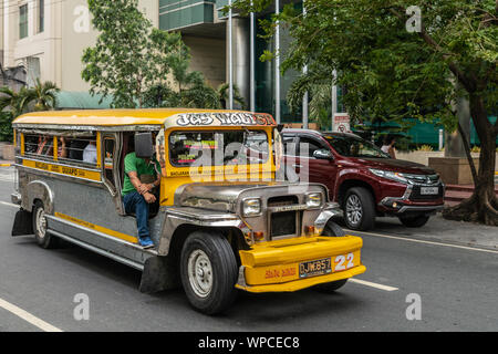 Manila, Philippines - March 5, 2019: Metalic and yellow long  Jeep Public Transport called Jay Walter in street. Side and front view. People inside. G Stock Photo