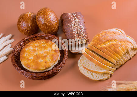 Bread and pita bread in a wicker basket with wheat. Stock Photo