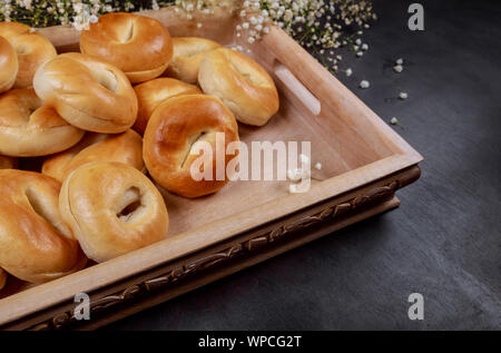 Lot of fresh mini bagels on a wooden tray. Stock Photo