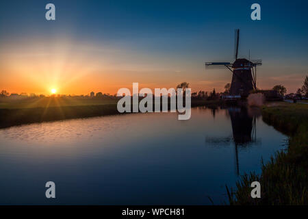 Sunset behind a 17th century Driemanspolder windmill Stock Photo