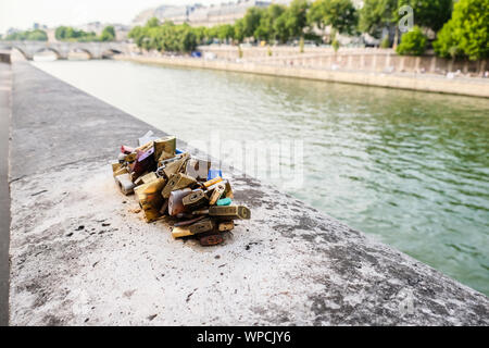 Cluster of padlocks locked together on riverbank of the Seine river in Paris Stock Photo