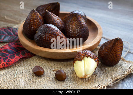 salak fruit or snake fruit native to java island on wooden plate Stock Photo