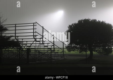 Deserted bleachers under floodlights on a foggy morning, northern California. Stock Photo