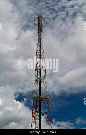 View of a radio tower against the sky with white cloud in portrait orientation Stock Photo