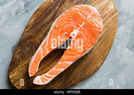 Fresh raw salmon fish steak on dark stone background. Creative layout made of fish, top view, flat lay, mockup, overhead. Healthy food concept Stock Photo