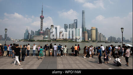 Shanghai, China. 08th Sep, 2019. Tourists stand at the promenade 'The Bund' at the Huangpu river with a view of the skyline of the special economic zone Pudong with its skyscrapers. On the left you can see the Oriental Pearl Tower and on the right the Shanghai Tower. Credit: Swen Pförtner/dpa/Alamy Live News Stock Photo